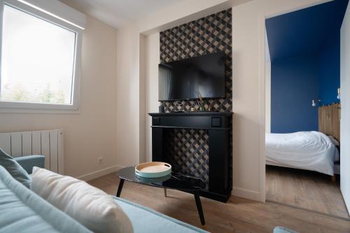 a living room with a fireplace and a bed at Résidence St Marc - L'Art Déco - Centre ville in Quimper
