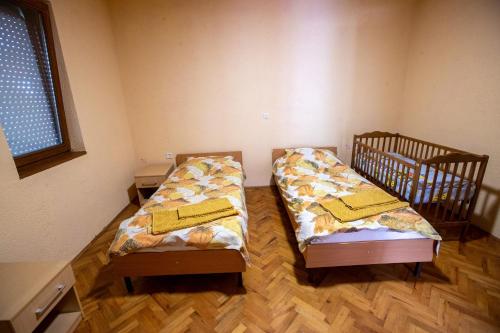 2 łóżka pojedyncze w pokoju z drewnianą podłogą w obiekcie Crystal w Ochrydzie