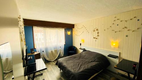 ein Schlafzimmer mit einem schwarzen Bett und einem Fenster in der Unterkunft Hôtel Le Valéran in Ligny-en-Barrois