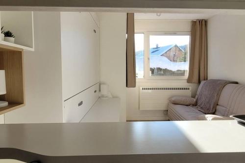 a living room with a couch and a window at Appartement 20m², tout confort, entièrement rénové in Prémanon