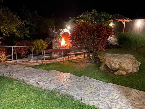 a garden with a stone bench and a fire place at Domaine Macabou in Le Vauclin