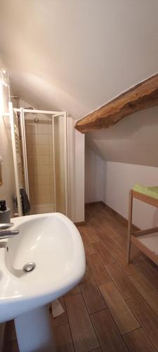 a bathroom with a white sink and a wooden floor at Gîte-Région centre-Sologne 41 proche Lamotte Beuvron in Nouan-le-Fuzelier