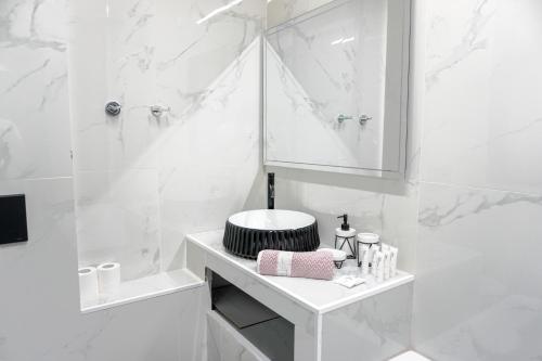 een witte badkamer met een wastafel en een spiegel bij Athenian Dream Suite in Athene