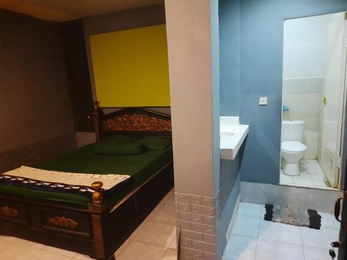 Banyuwangi Baru Homestay في بانيووانجى: غرفة نوم بسرير وحمام مع حوض