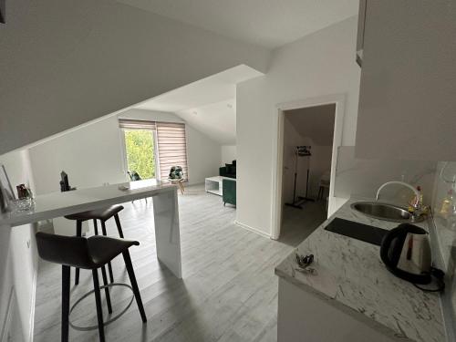 a kitchen with a sink and a counter with stools at Apartmani Zeleni Vrtovi in Visoko