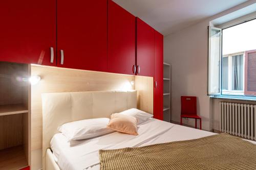 a bedroom with red cabinets and a white bed at JOIVY Al Duomo guest house in Como