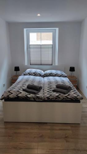 a bed with two pillows on it in a bedroom at Stare Miasto in Kłodzko