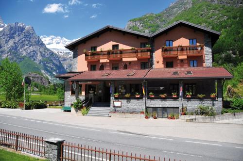 a building on the side of a road with mountains at Hotel Ristorante Miramonti in Val Masino