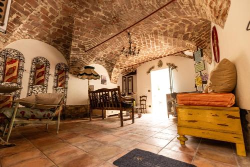 a room filled with furniture and a brick wall at Le calendule,relax home & wine in Strevi