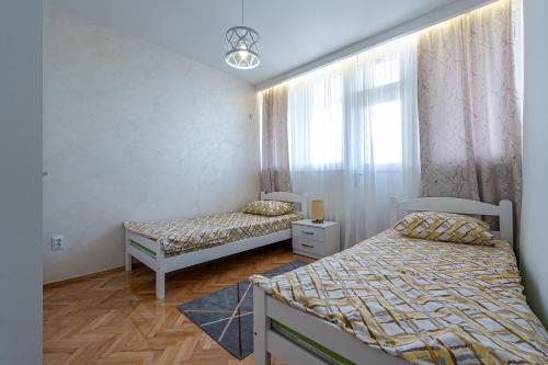 1 Schlafzimmer mit 2 Betten und einem Fenster in der Unterkunft Clock Tower Lux Apartment in Podgorica