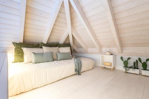 LODO Suits Ala - Studio mezanino by HD في فارو: سرير في غرفة ذات سقف خشبي