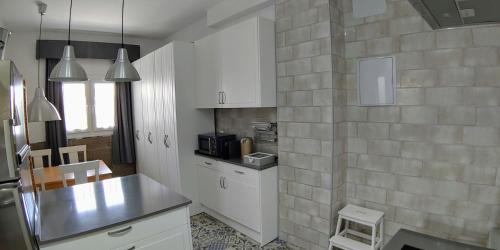 a kitchen with white cabinets and a counter top at Casa Vistas a Trafalgar sólo familias o parejas - Parking privado opcional - in Conil de la Frontera