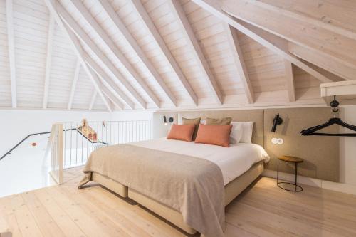 a bedroom with a large bed and a wooden ceiling at LODO Suits Se - Mezanino room by HD in Faro