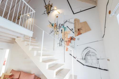 a staircase in a house with drawings on the wall at LODO Suits Se - Mezanino room by HD in Faro