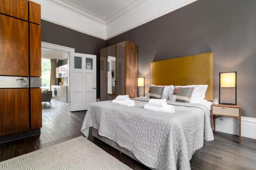 a bedroom with a large bed with two towels on it at Charlotte Rise - Urban Apartments in Bristol