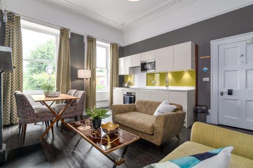 a living room with a couch and a table at Charlotte Rise - Urban Apartments in Bristol