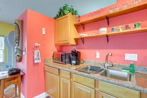 cocina con fregadero y pared rosa en Vibrant Condo - Walk to Indian Rocks Beach!, en Clearwater Beach