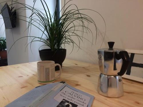 a wooden table with a coffee pot and a book at Small Peace Oasis in Zagreb
