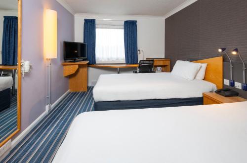 pokój hotelowy z dwoma łóżkami i telewizorem w obiekcie Holiday Inn Express London Chingford, an IHG Hotel w Londynie