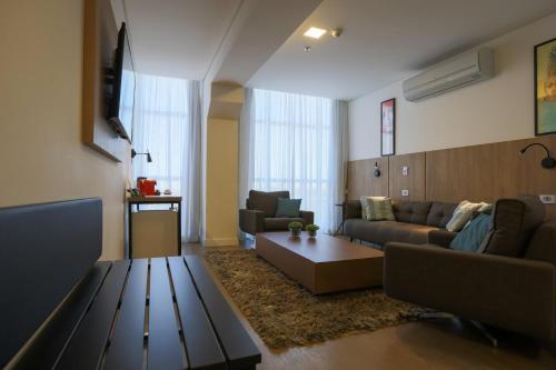 a living room with a couch and a table at Transamerica Executive Maringá in Maringá