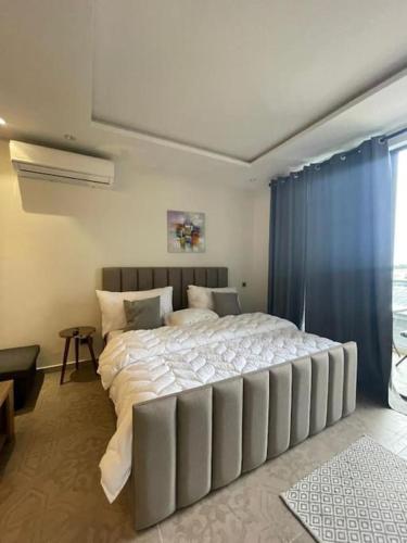 - une chambre avec un grand lit blanc et des rideaux bleus dans l'établissement Luxury Cantonments Suite, à Accra