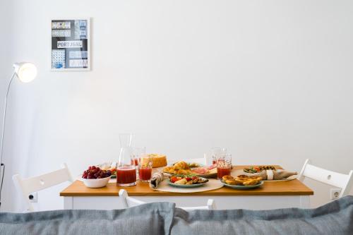 Una mesa cubierta con platos de comida y bebidas. en Host Wise - Charming Welcoming Flat - Centrally Located, en Oporto