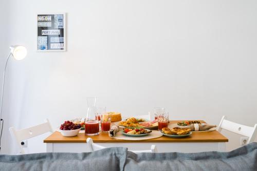 a table topped with plates of food and drinks at Charming Welcoming Flat - Centrally Located in Porto