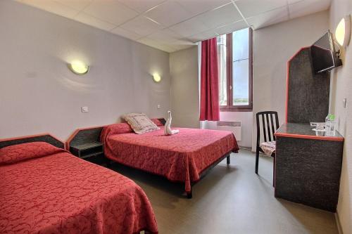 a hotel room with two beds and a window at Hotel Central in Saint-Pierre-dʼAlbigny