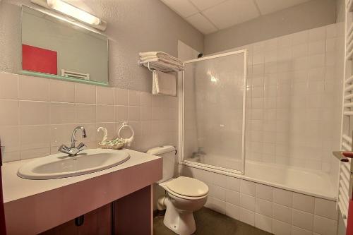 a bathroom with a sink and a toilet and a shower at Hotel Central in Saint-Pierre-dʼAlbigny