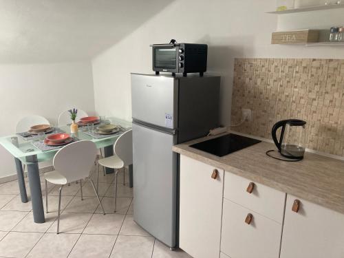 a kitchen with a refrigerator and a table with chairs at Rijeka city center apartment in Rijeka
