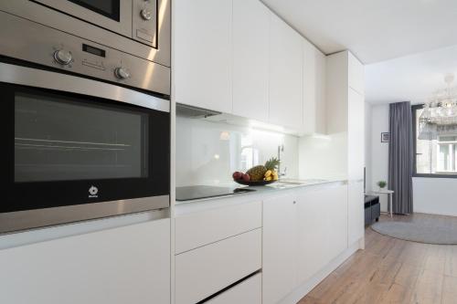 Una cocina con gabinetes blancos y un microondas. en Host Wise - Charming Welcoming Flat - Centrally Located, en Oporto