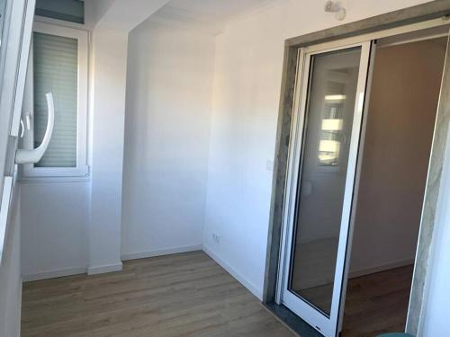 an empty room with a glass door and a window at Carcavelos Beach Five Guests apartment in Oeiras