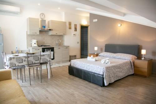 um quarto com uma cama e uma cozinha com uma mesa em Happy Home em Giardini Naxos
