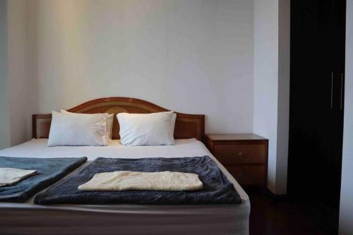 Una cama con dos toallas encima. en 2BR The Belleza at Permata Hijau 18th Floor en Yakarta