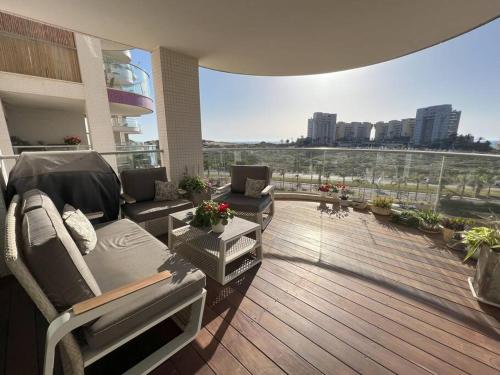 - un balcon avec un canapé et des chaises dans un bâtiment dans l'établissement Luxury sea view apartment, à Tel Aviv