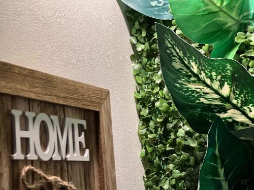 a house plant next to a wooden frame with the words home at Sweet Home Apartament in Predeal