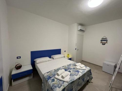 1 dormitorio con 1 cama con toallas en La Finestrella, en Belvedere Marittimo