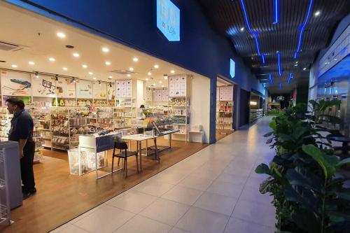 a man standing in a grocery store aisle with a store at Lovely 4paxs Kozi Square comfort Studio Home 2A in Kuching