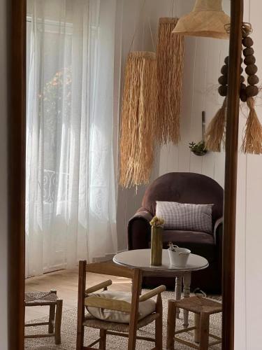 a living room with a chair and a table at Le vieux poirier à la Plaine des Cafres in Le Tampon