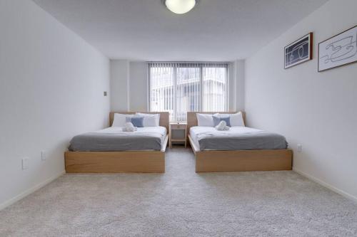 - 2 lits dans une chambre avec fenêtre dans l'établissement Modern & Spacious 2BR + Den Condo @Crystal City, à Arlington