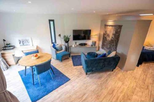 a living room with a table and blue chairs at Beautiful garden apartment with private patio and garden view in Dublin