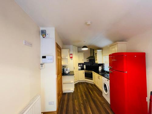 uma cozinha com um frigorífico vermelho num quarto em River Cottage em Mullingar