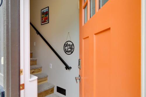 an orange door in a hallway with stairs at Anchorage Apartment with a View about 3 Mi to Airport in Anchorage