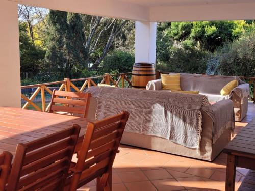 Un sofá en un patio con una mesa y sillas. en Eden Guesthouse, en Johannesburgo