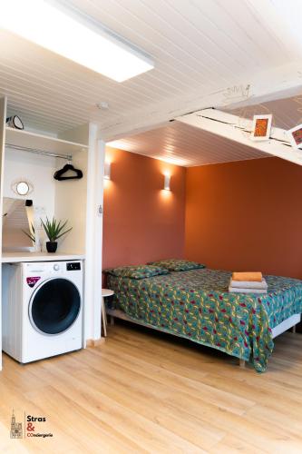 - une chambre avec un lit et un lave-linge dans l'établissement Lyam, à Strasbourg