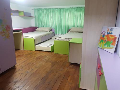 um quarto com 2 camas e piso em madeira em Tirana Central Apartment em Tirana