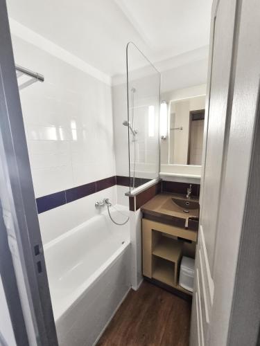 une salle de bain avec une baignoire blanche et un lavabo dans l'établissement Village Cap Esterel, P2 face golf et mer, à Agay