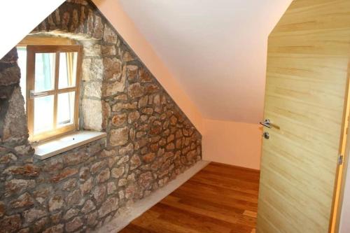 a room with a stone wall and a window at A stone house 'Pojata' in Cista Provo