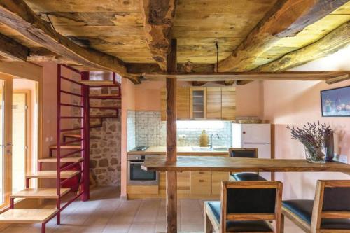 a kitchen with a wooden ceiling and a table and chairs at A stone house 'Pojata' in Cista Provo