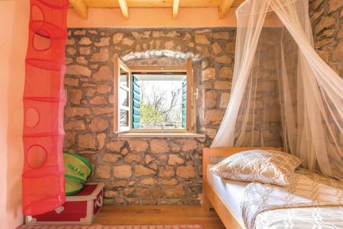 a bedroom with a bed and a stone wall at A stone house 'Pojata' in Cista Provo